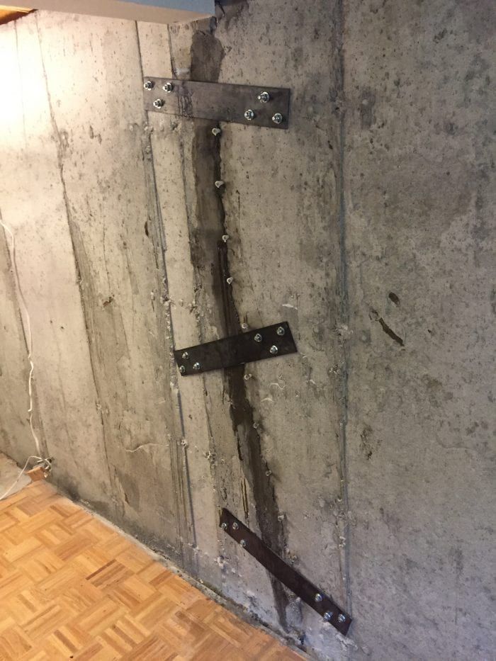 Un grand bâtiment est en train d'être démoli avec beaucoup de machines.