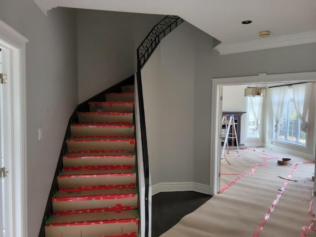 Un escalier en colimaçon avec du ruban rouge sur les marches se trouve dans un couloir.