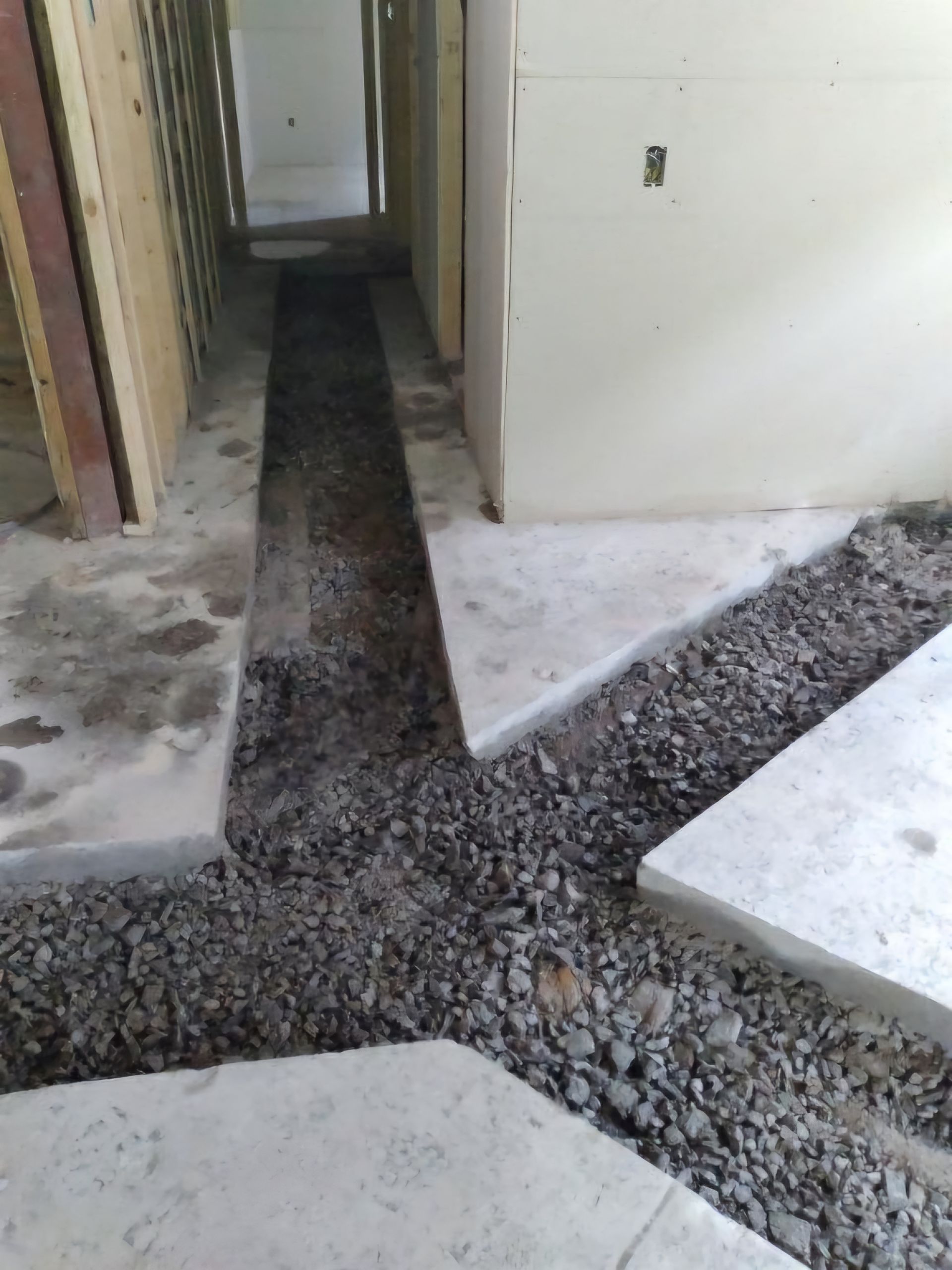 Un chantier avec un sol en béton et du gravier.