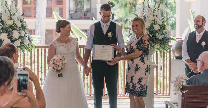 A Bride and Groom Are Holding Hands During Their Wedding Ceremony — GinaS Cairns Tropical Weddings in Parramatta Park, QLD