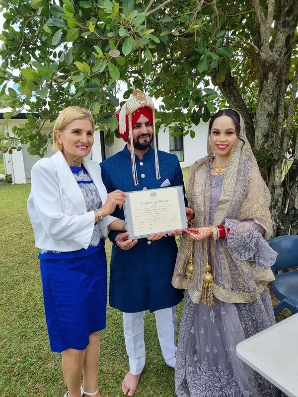 A Woman is Giving a Certificate to a Bride and Groom — GinaS Cairns Tropical Weddings in Parramatta Park, QLD