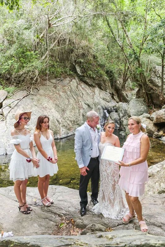 A Bride and Groom Are Standing Next to a River With Their Wedding — GinaS Cairns Tropical Weddings in Parramatta Park, QLD