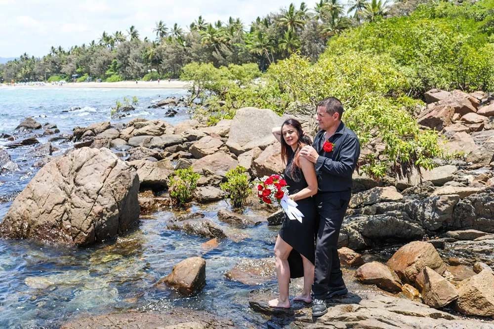 A Man and a Woman Are Standing on a Rocky Beach Near the Ocean — GinaS Cairns Tropical Weddings in Parramatta Park, QLD