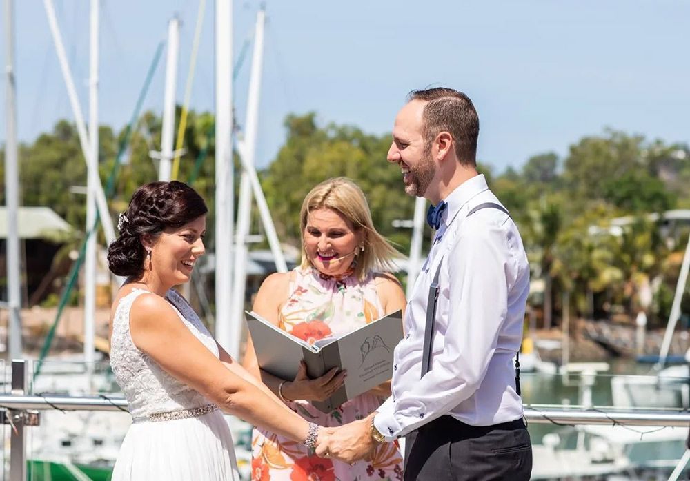 A Bride and Groom Are Holding Hands During Their Wedding Ceremony — GinaS Cairns Tropical Weddings in Parramatta Park, QLD