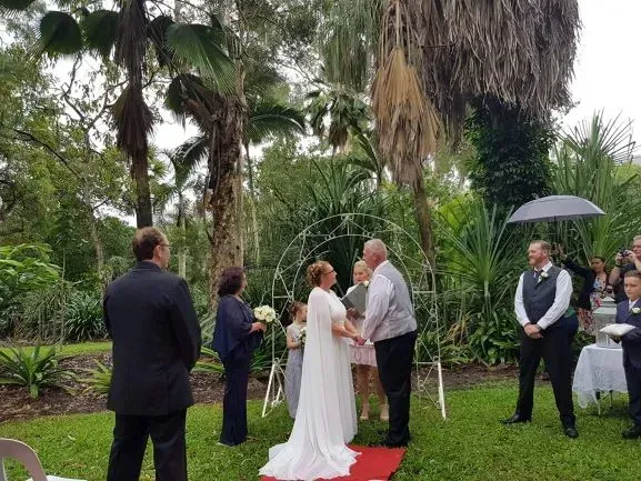 A Bride and Groom Are Holding Hands During Their Wedding Ceremony — GinaS Cairns Tropical Weddings in Parramatta Park, QLD