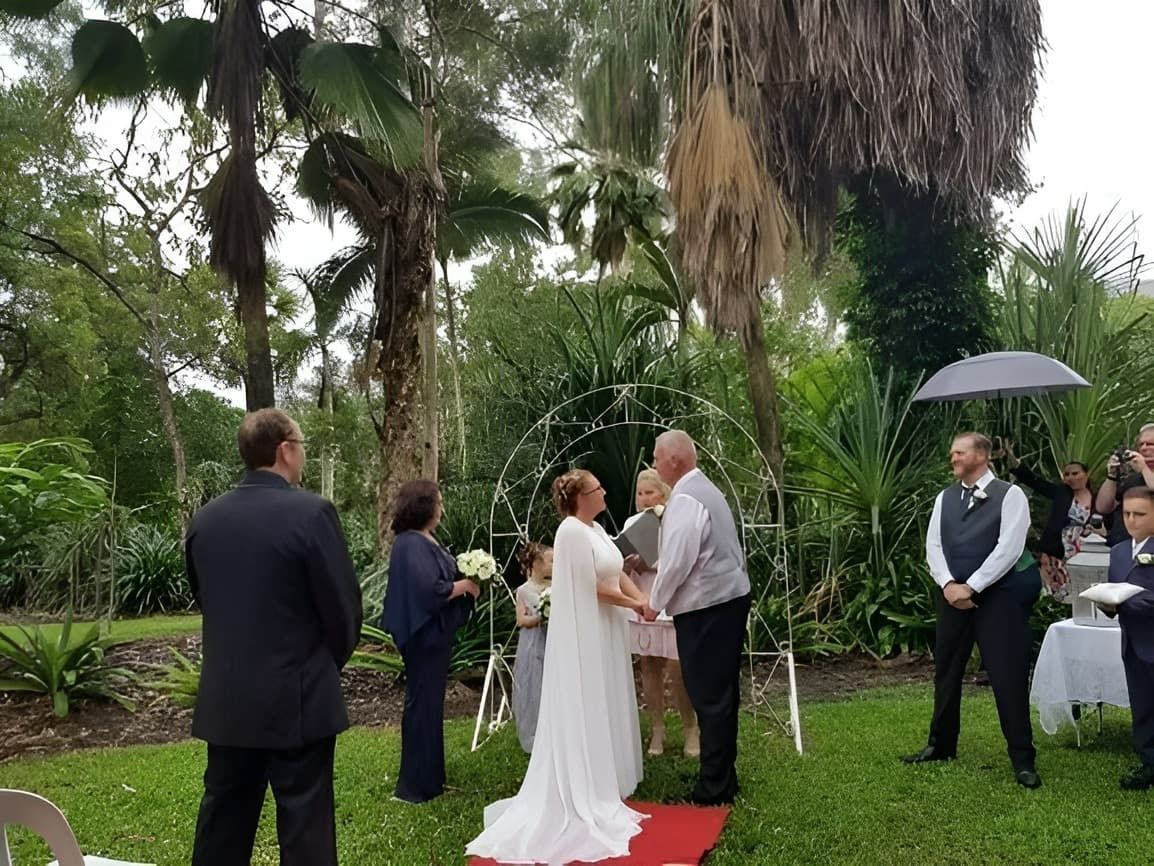 A Bride and Groom Are Holding Hands During Their Wedding Ceremony — GinaS Cairns Tropical Weddings in Parramatta Park, QLD