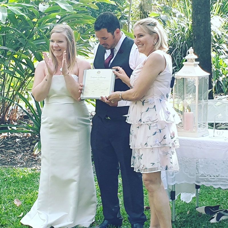 A Bride and Groom Standing Next to Each Other Holding a Certificate — GinaS Cairns Tropical Weddings in Parramatta Park, QLD