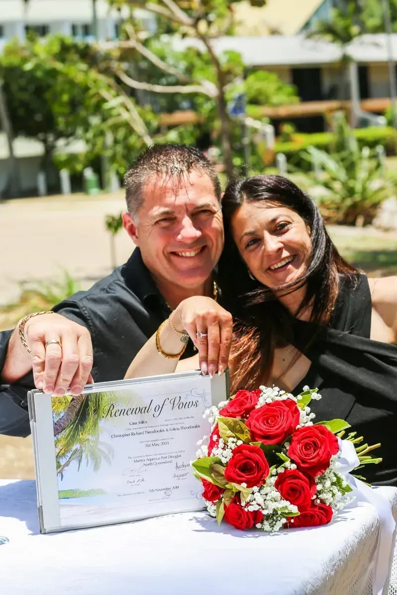 A Man and a Woman Are Sitting at a Table With a Bouquet of Red Roses — GinaS Cairns Tropical Weddings in Parramatta Park, QLD