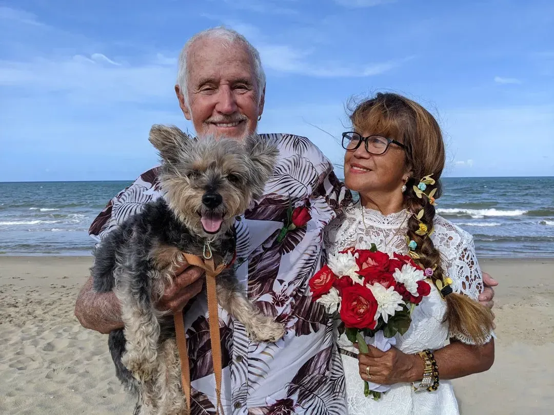A Man and Woman Are Posing for a Picture With Their Dog on the Beach — GinaS Cairns Tropical Weddings in Parramatta Park, QLD