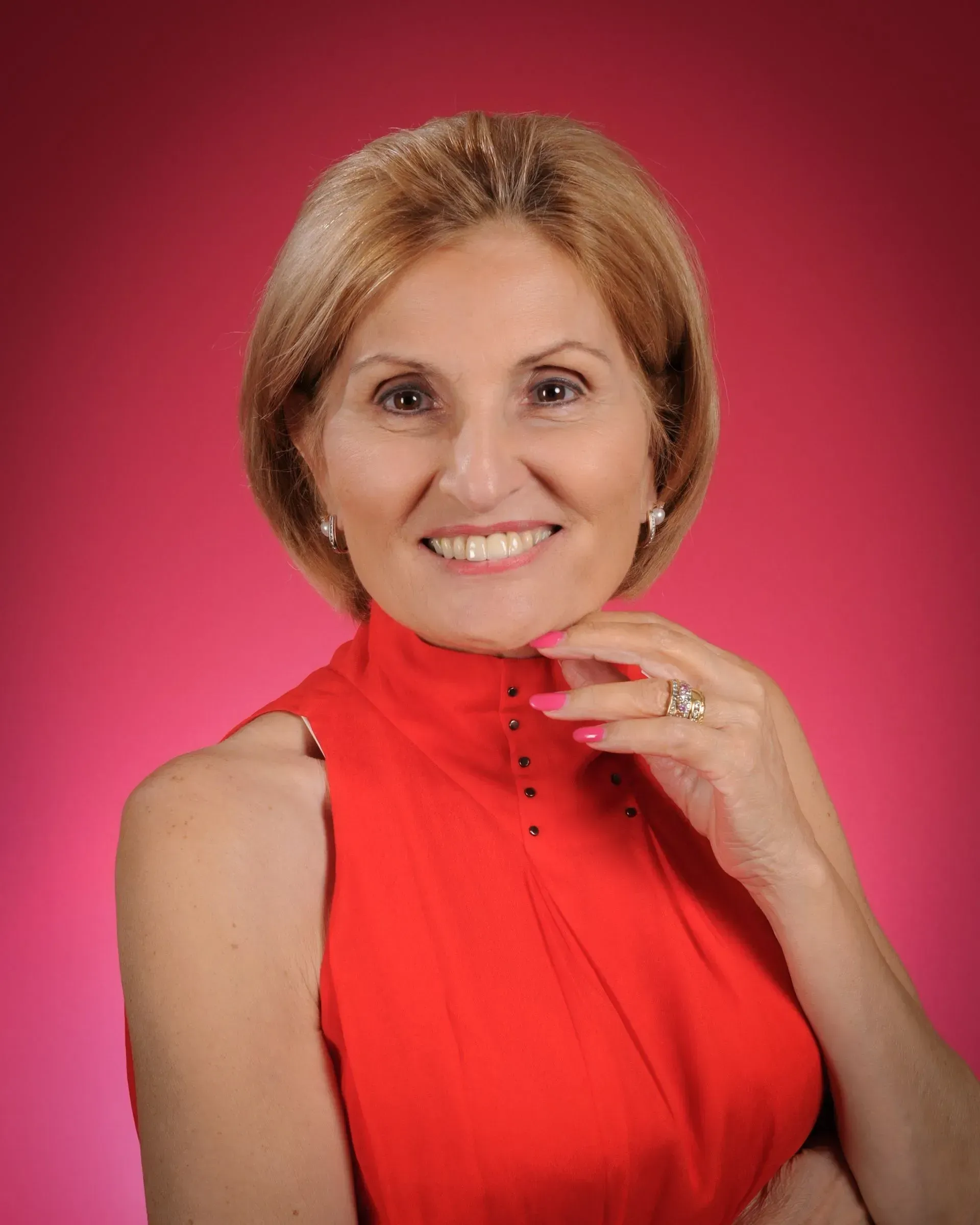 A Woman in a Red Dress is Smiling and Holding Her Hand to Her Face — GinaS Cairns Tropical Weddings in Palm Cove, QLD