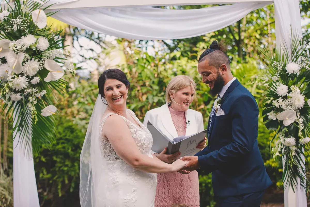 A Bride and Groom Are Holding Hands During Their Wedding Ceremony — GinaS Cairns Tropical Weddings in Parramatta Park, QLD