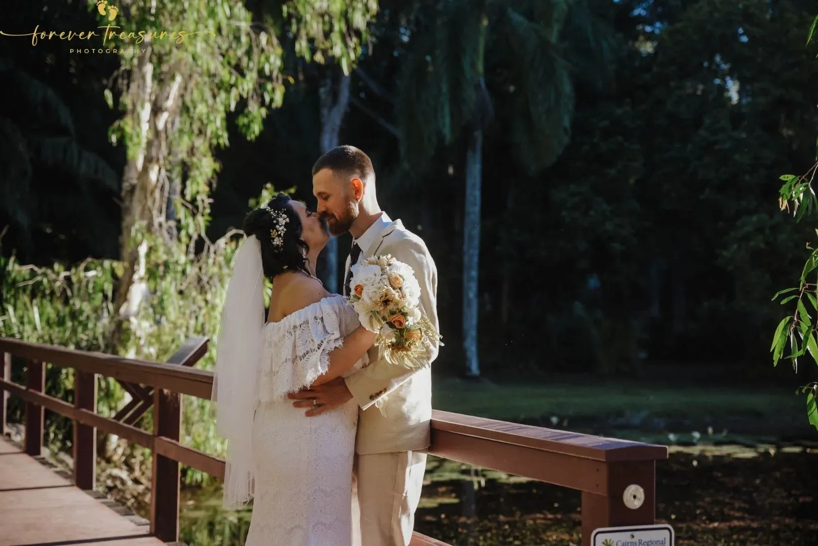 A Bride and Groom Are Kissing on a Wooden Bridge — GinaS Cairns Tropical Weddings in Parramatta Park, QLD