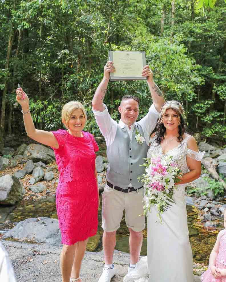A Bride and Groom Are Next to Each Other Holding a Certificate — GinaS Cairns Tropical Weddings in Parramatta Park, QLD