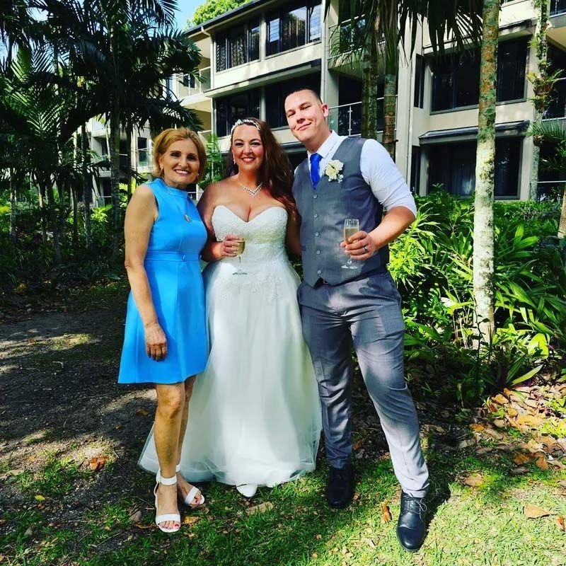 A Bride and Groom Pose for a Picture With a Woman in a Blue Dress — GinaS Cairns Tropical Weddings in Parramatta Park, QLD