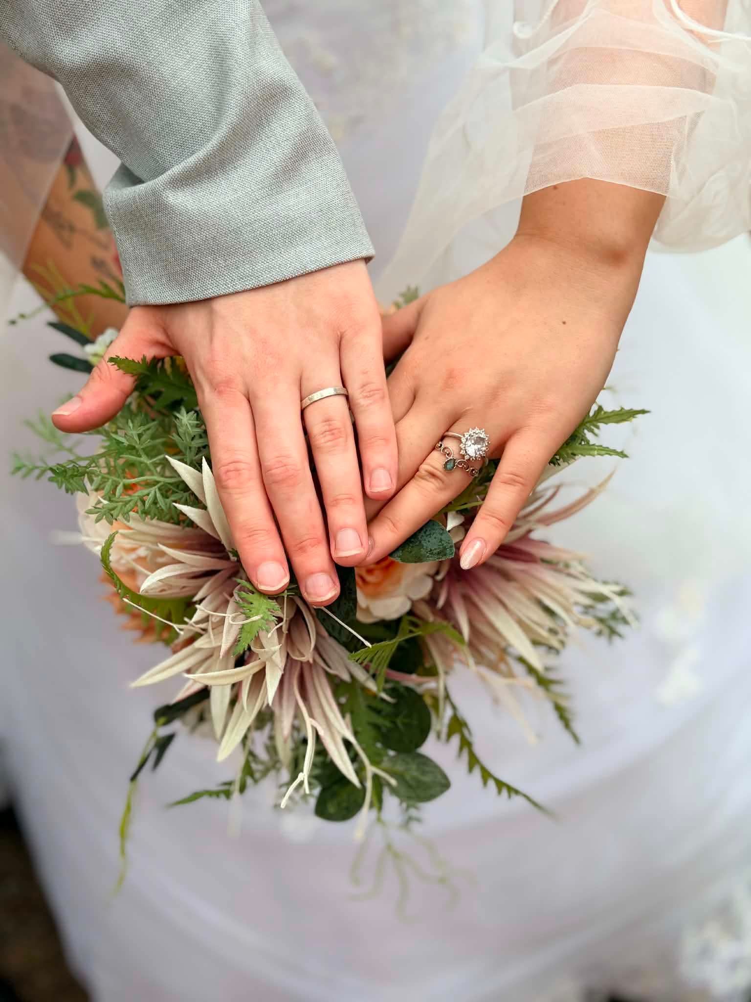 Two hands with wedding rings resting on a bridal bouquet — GinaS Cairns Tropical Weddings in Parramatta Park, QLD