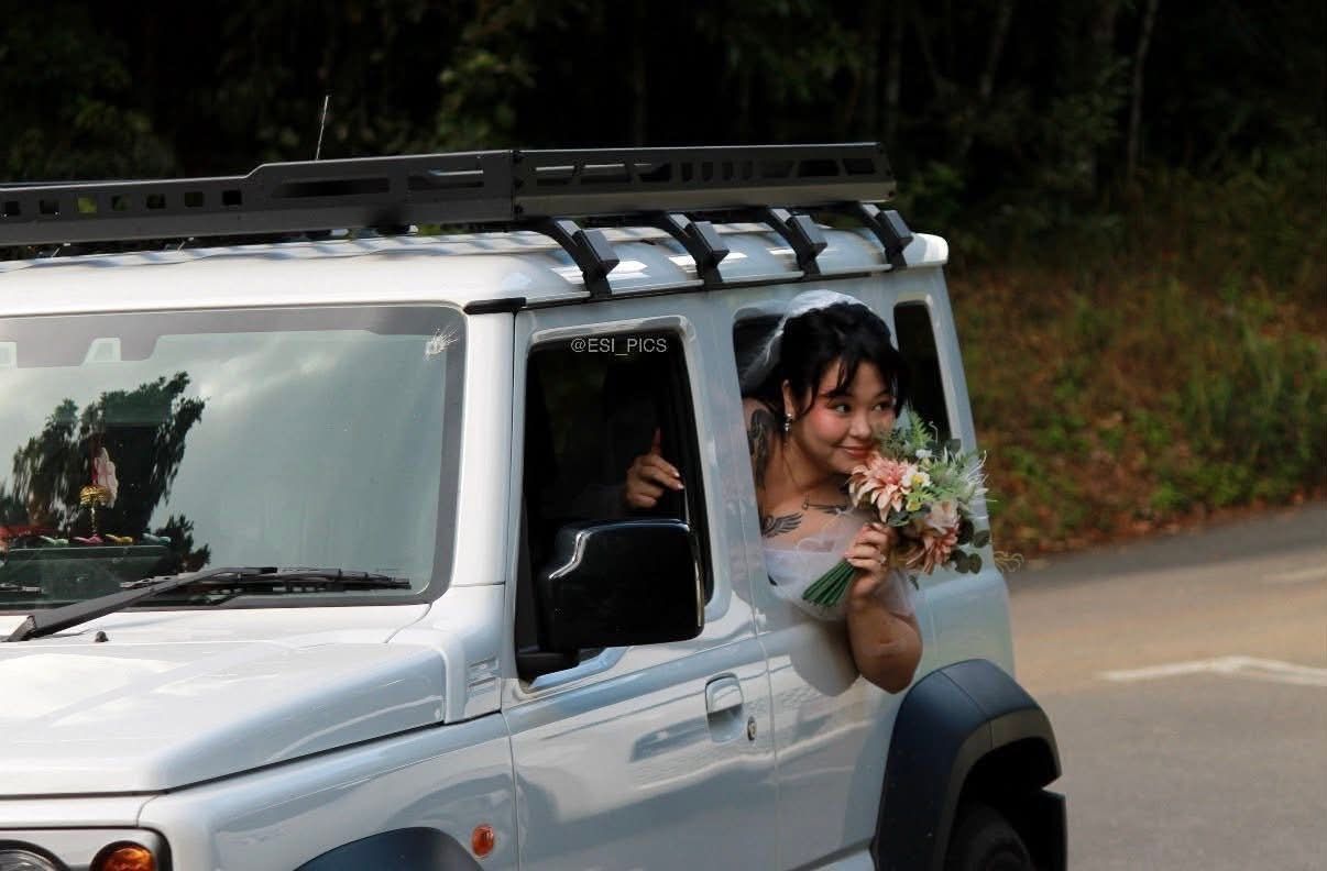 Person smiling from a white SUV window, holding a bouquet — GinaS Cairns Tropical Weddings in Parramatta Park, QLD