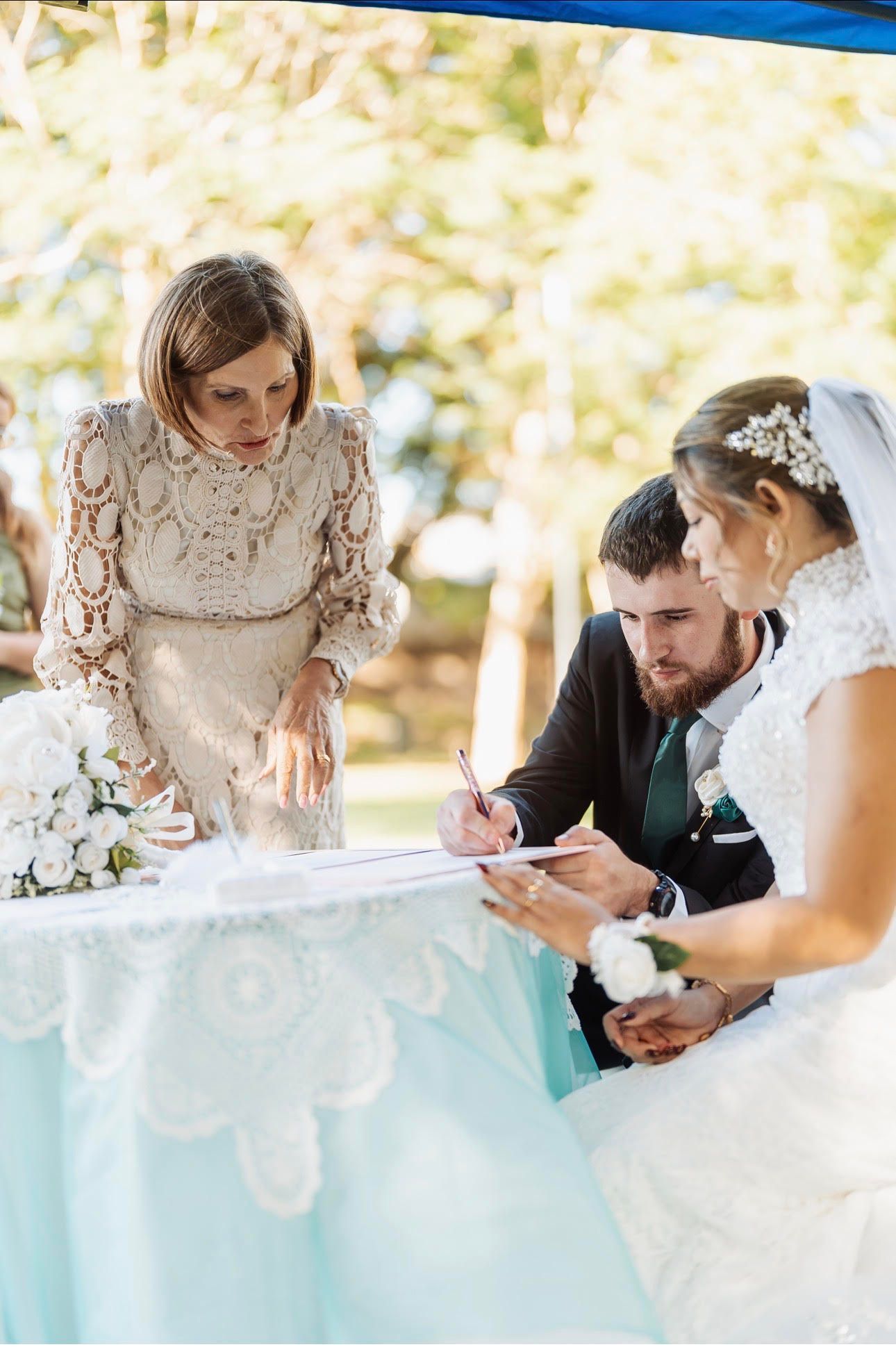 Wedding guests gathered around a signing table under a blue canopy — GinaS Cairns Tropical Weddings in Parramatta Park, QLD