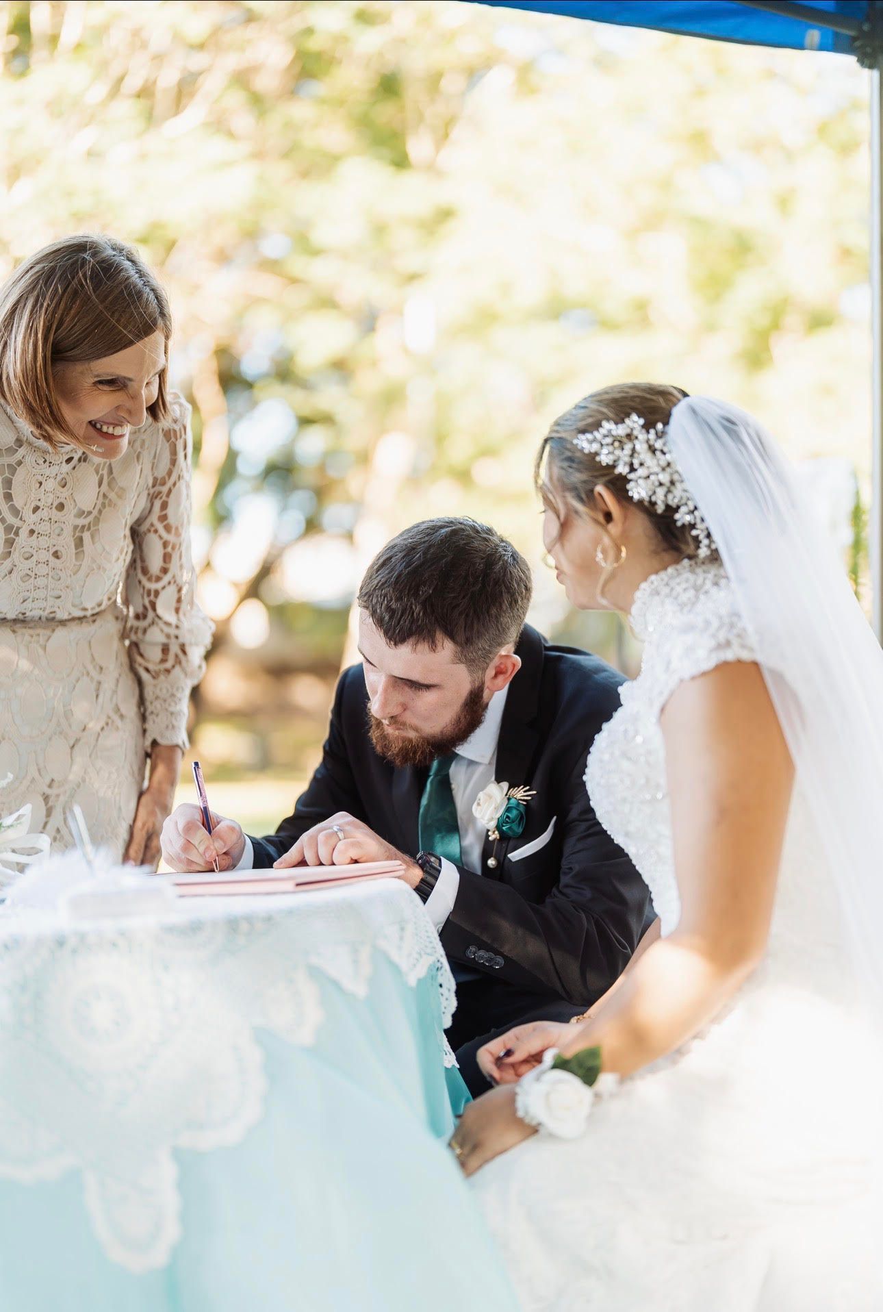 Bride and groom signing a wedding document under a canopy — GinaS Cairns Tropical Weddings in Parramatta Park, QLD