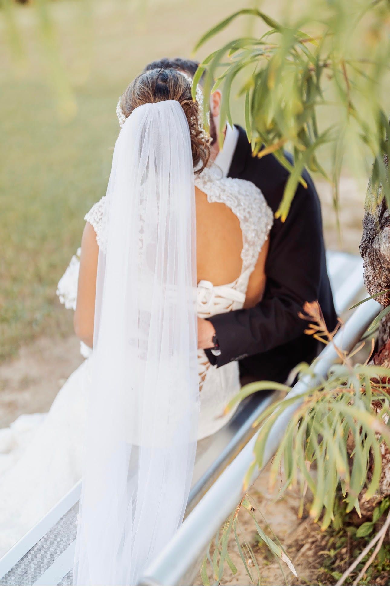 Bride and groom kissing outdoors by a railing — GinaS Cairns Tropical Weddings in Parramatta Park, QLD