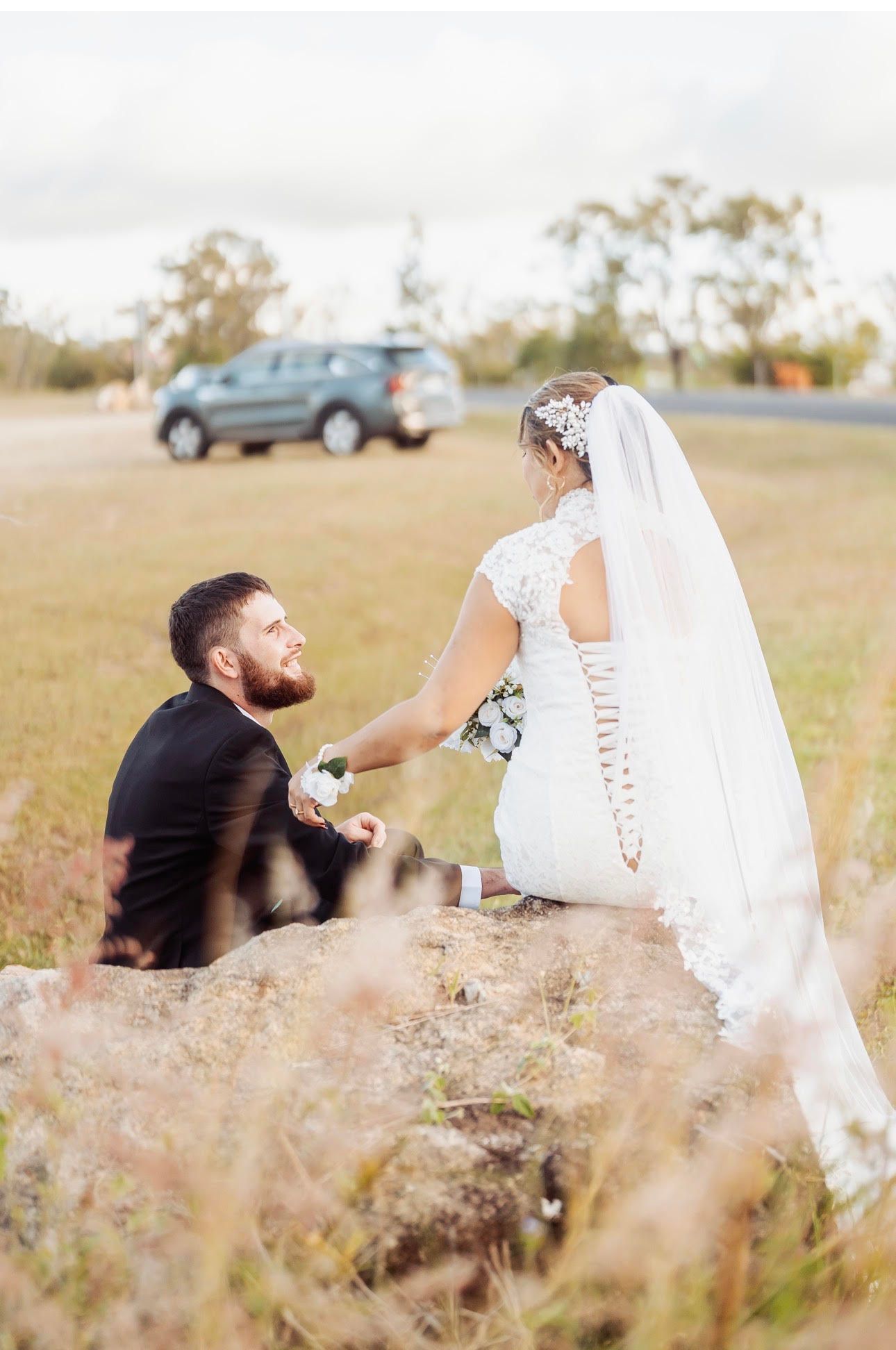 Bride in white dress and veil accepts a hand from a kneeling partner — GinaS Cairns Tropical Weddings in Parramatta Park, QLD