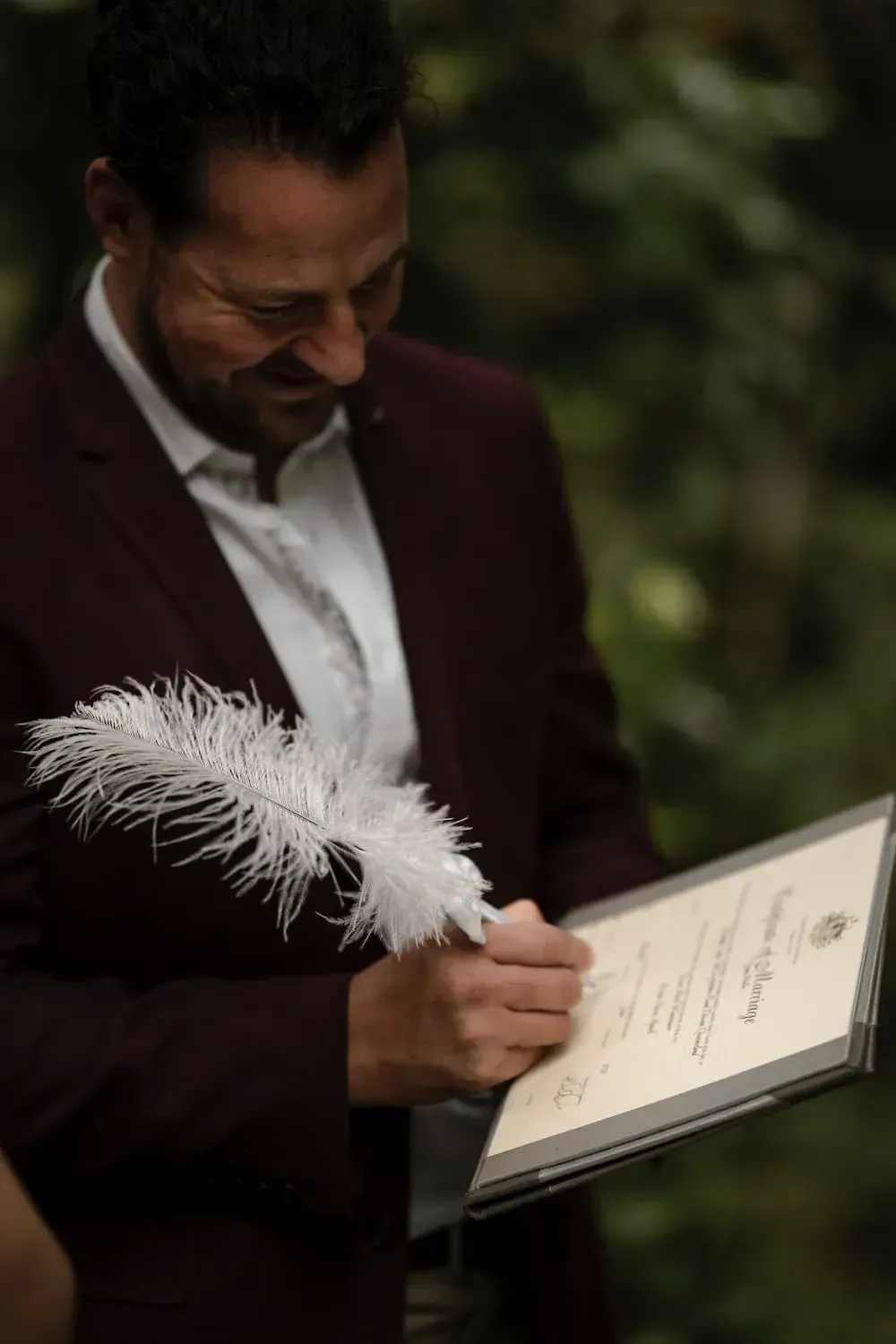 A Man in a Suit is Writing on a Piece of Paper With a Feather — GinaS Cairns Tropical Weddings in Parramatta Park, QLD