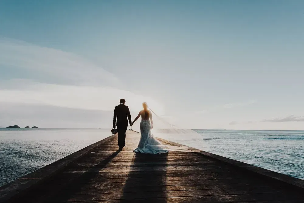 A Bride and Groom Are Walking Down a Pier Holding Hands — GinaS Cairns Tropical Weddings in Parramatta Park, QLD