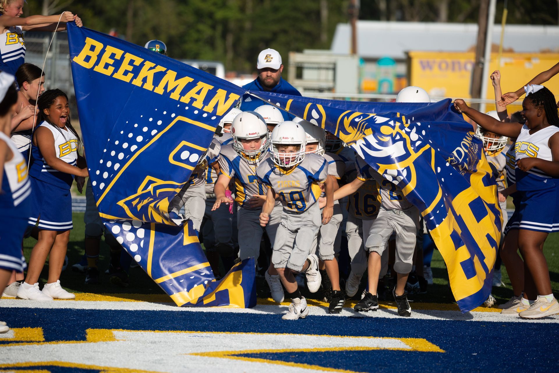 A group of young boys are playing a game of football on a field.