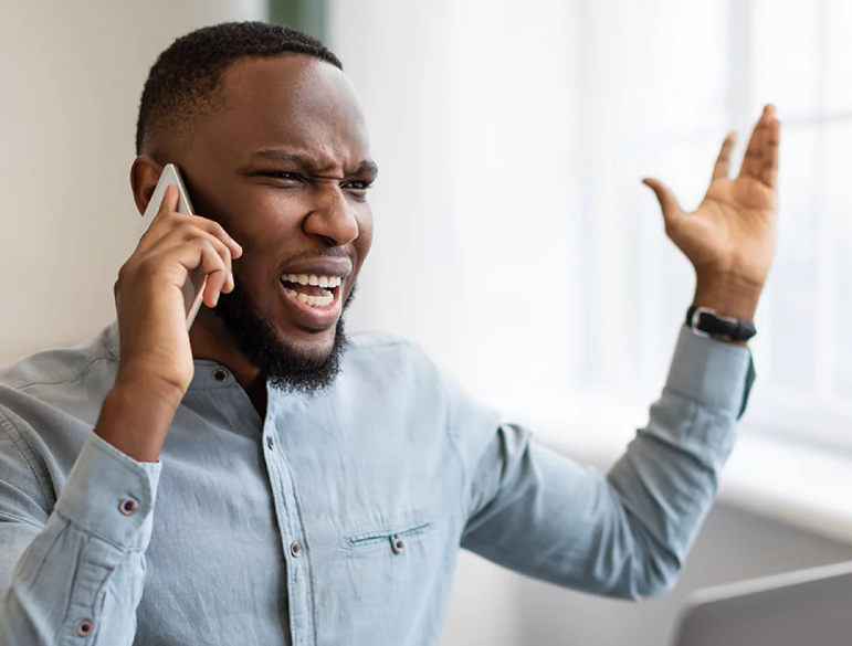 A man is angry while talking on a cell phone.