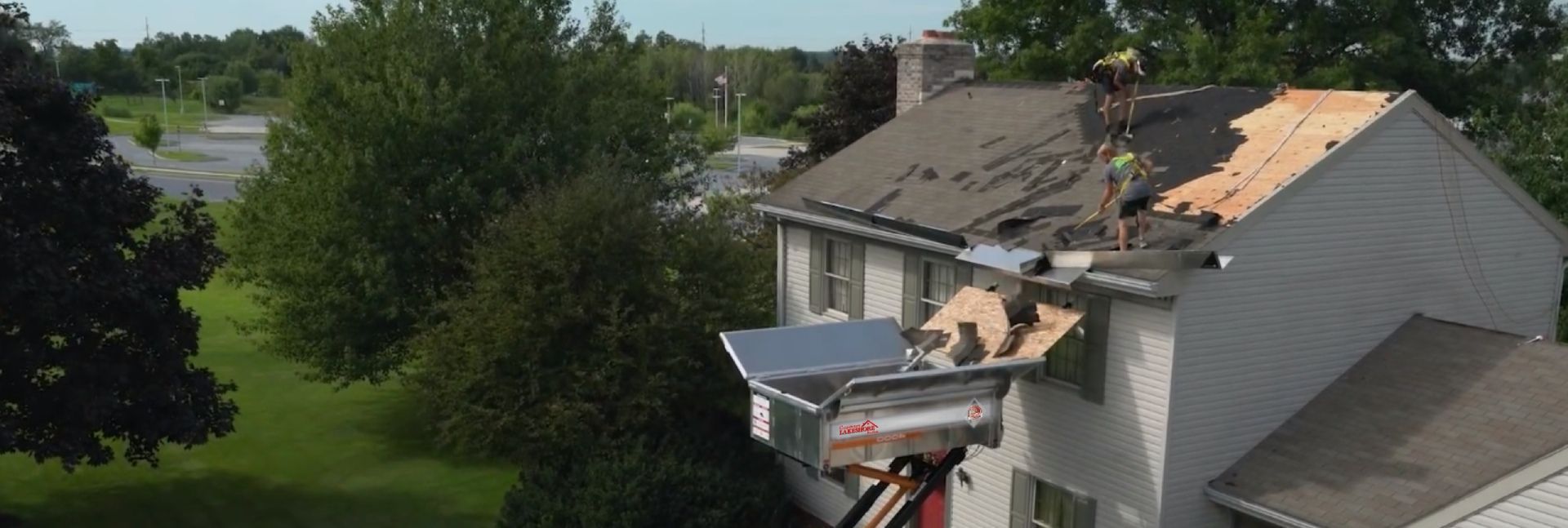 A man is working on the roof of a house.