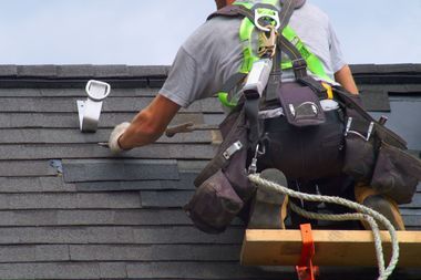 A man is working on the roof of a building.