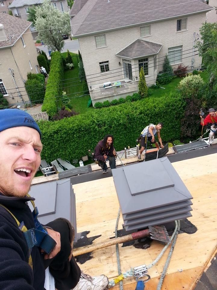 A man is taking a selfie on the roof of a house.