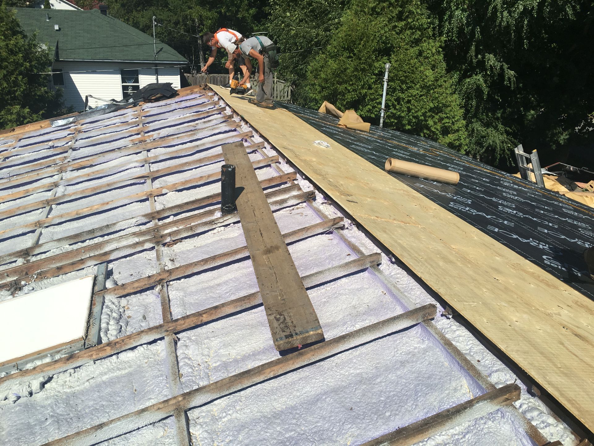 A group of men are working on the roof of a house.