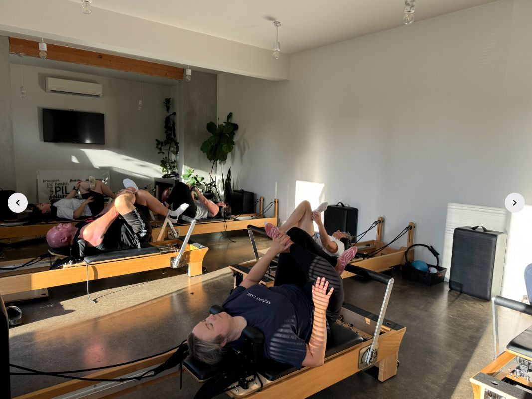 A group of women are doing pilates exercises in a gym.