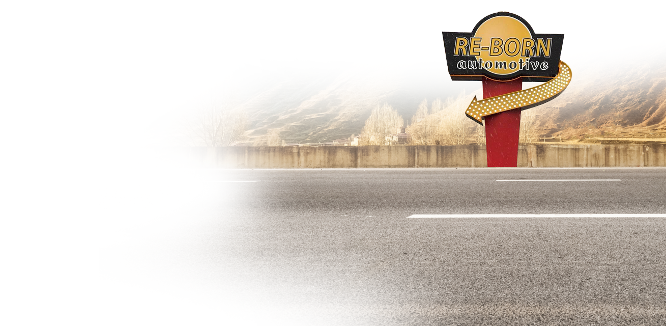 A road sign with an arrow directs to a diner in a mountain setting with a foggy sky. | Re-Born Automotive, Inc.