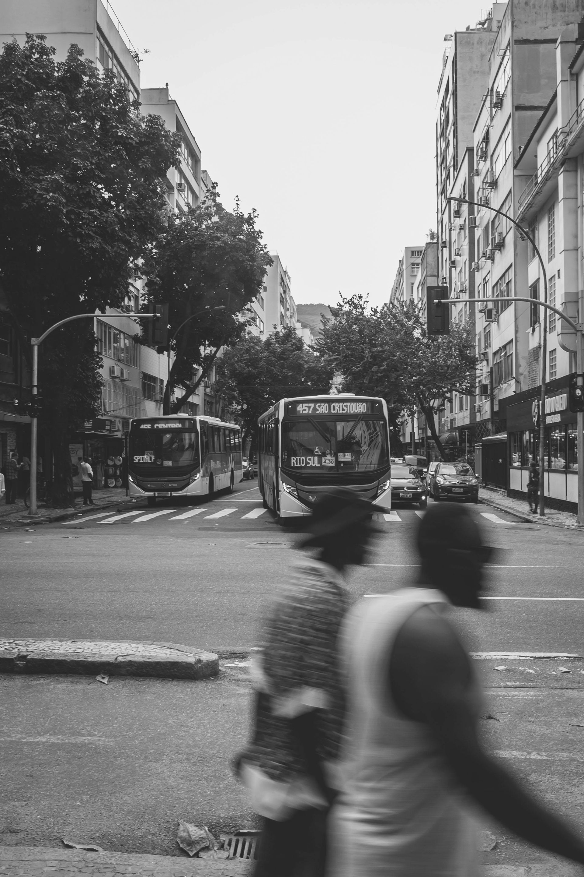 A black and white photo of a couple walking down a city street.