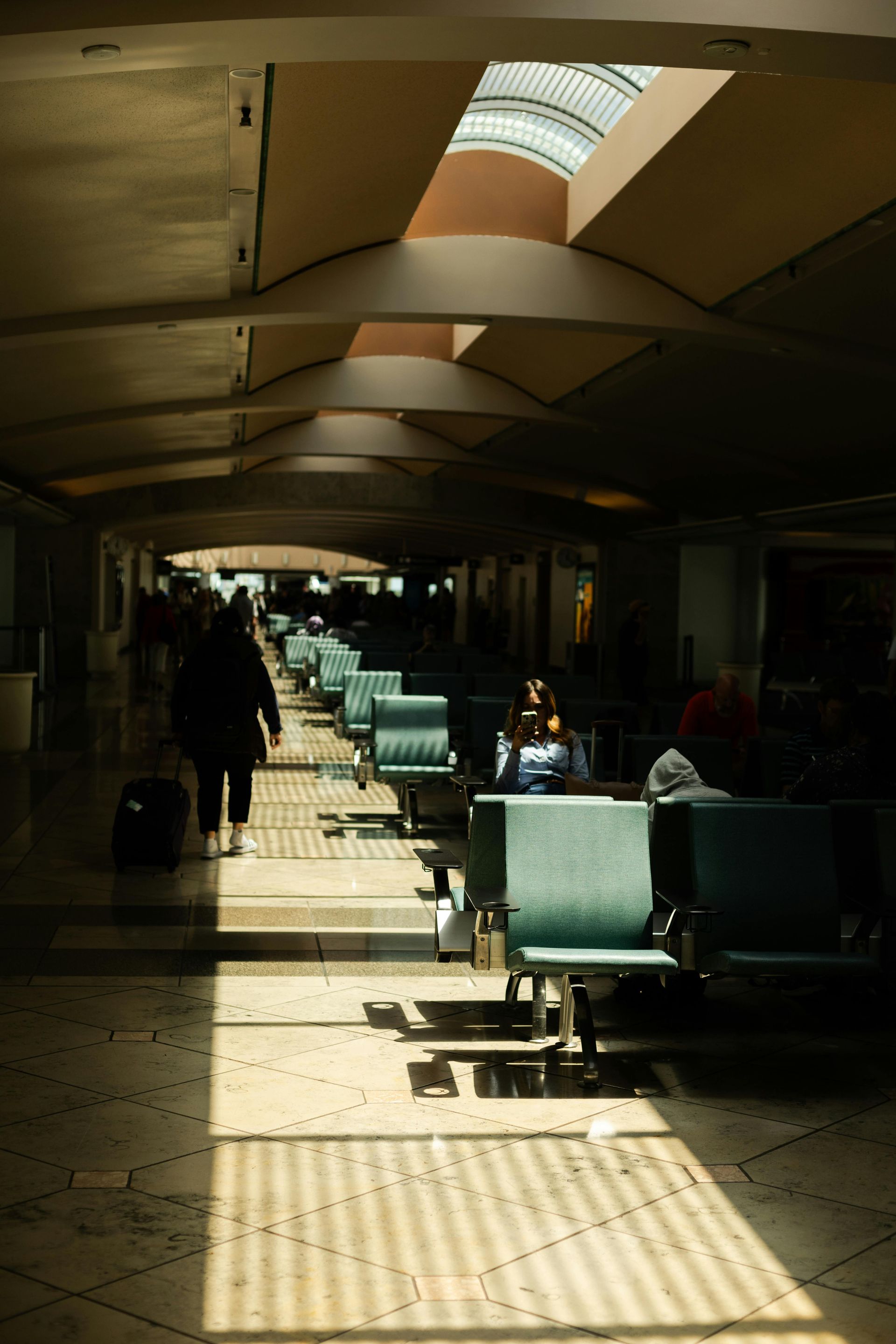 A row of green chairs in an airport waiting area