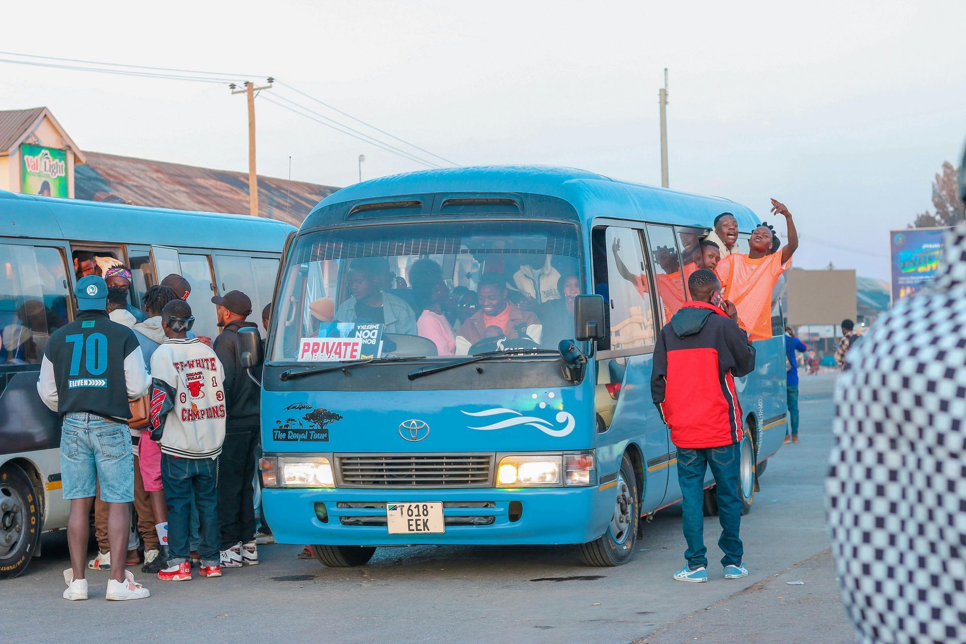A group of people are standing in front of a blue bus.
