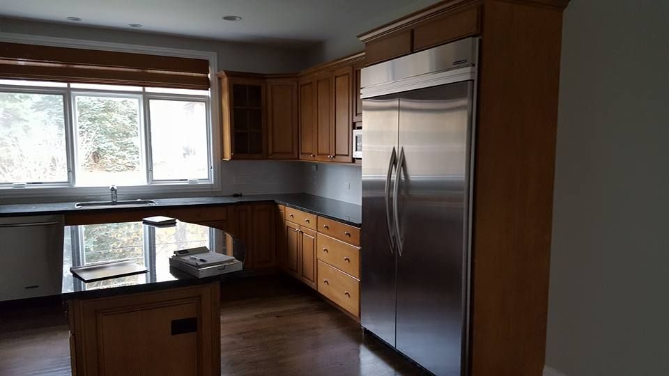 A kitchen with stainless steel appliances and wooden cabinets.