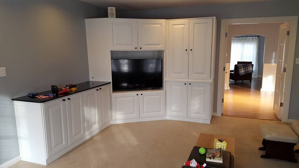 A living room with white cabinets and a flat screen tv.
