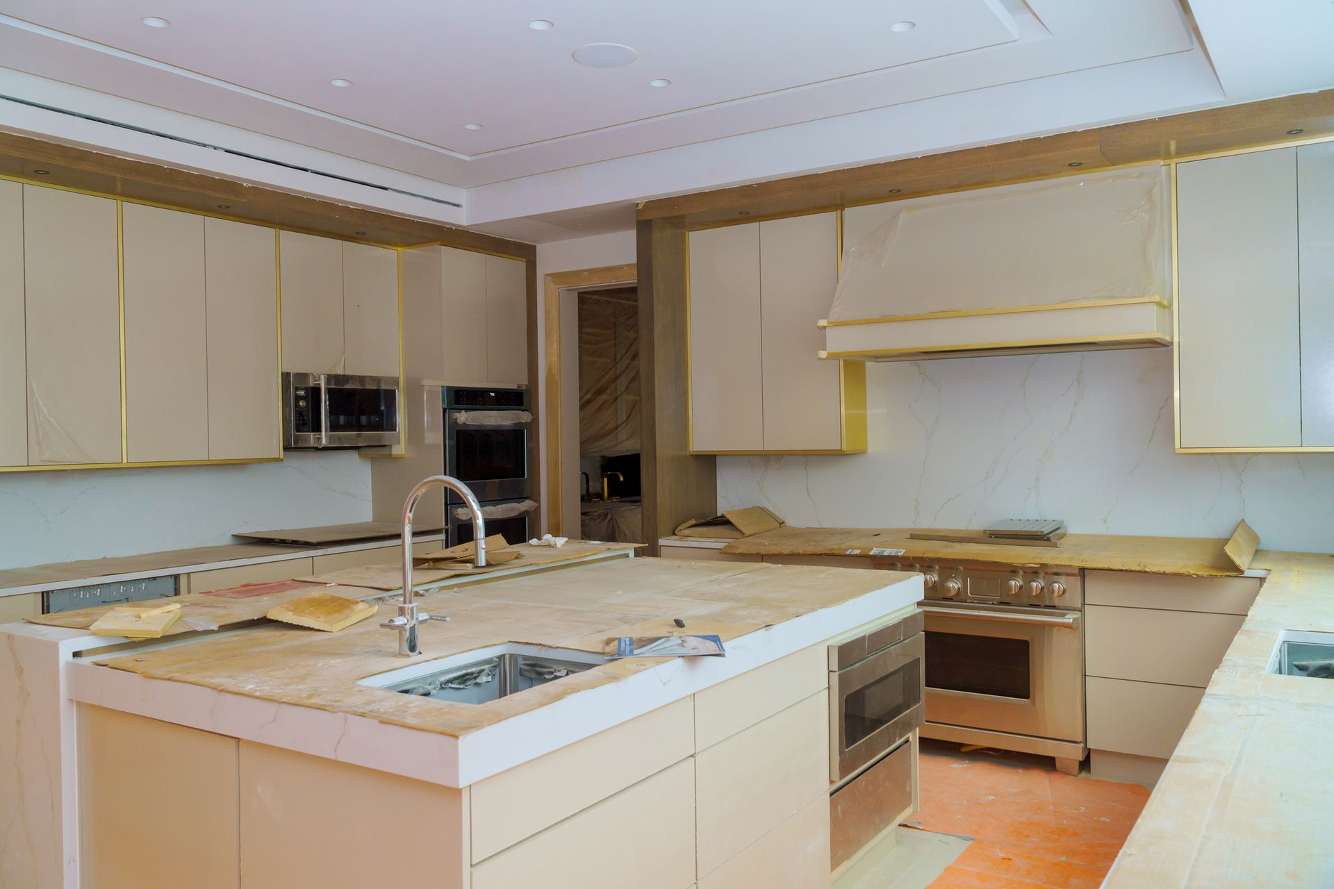 A kitchen with a large island, sink, stove, and oven.