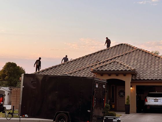 A man is standing on the roof of a house.