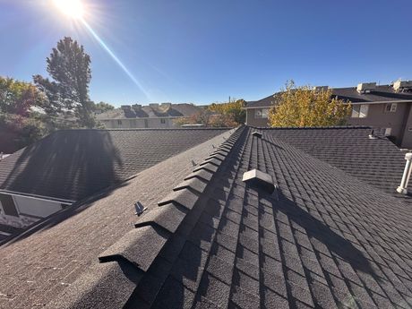 The sun is shining on the roof of a house