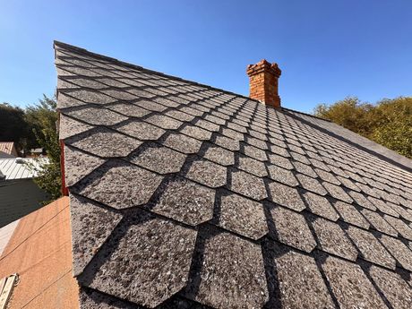 A close up of a roof with a chimney on top of it.