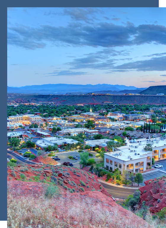 An aerial view of a city at night with mountains in the background.
