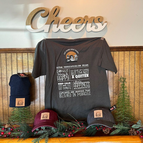 Merchandise display: T-shirt, beanies, and hats with logo, in front of 