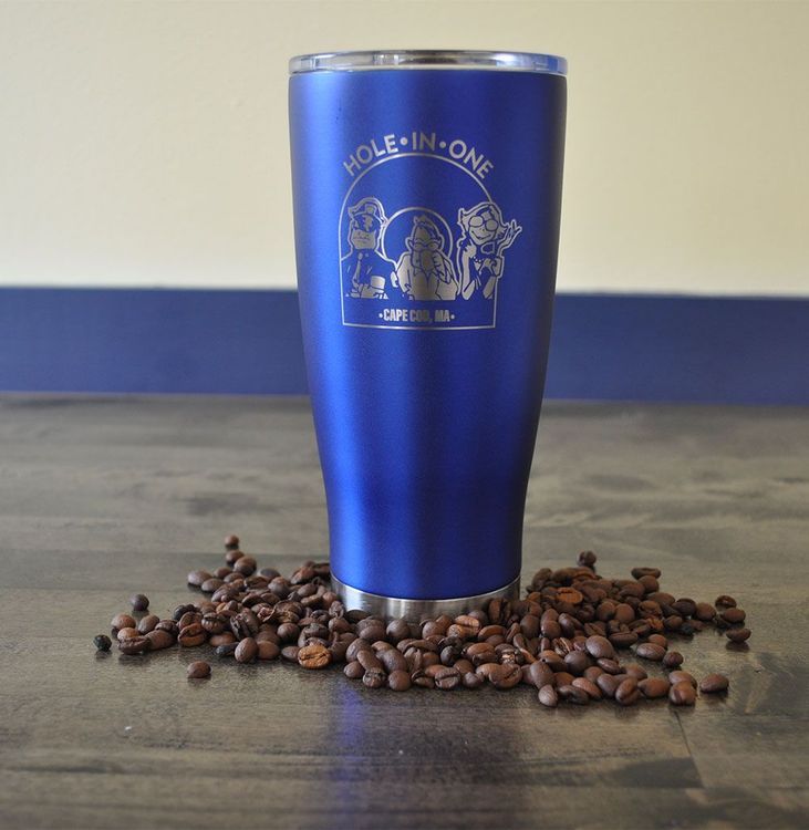 Blue tumbler with coffee beans scattered around the base