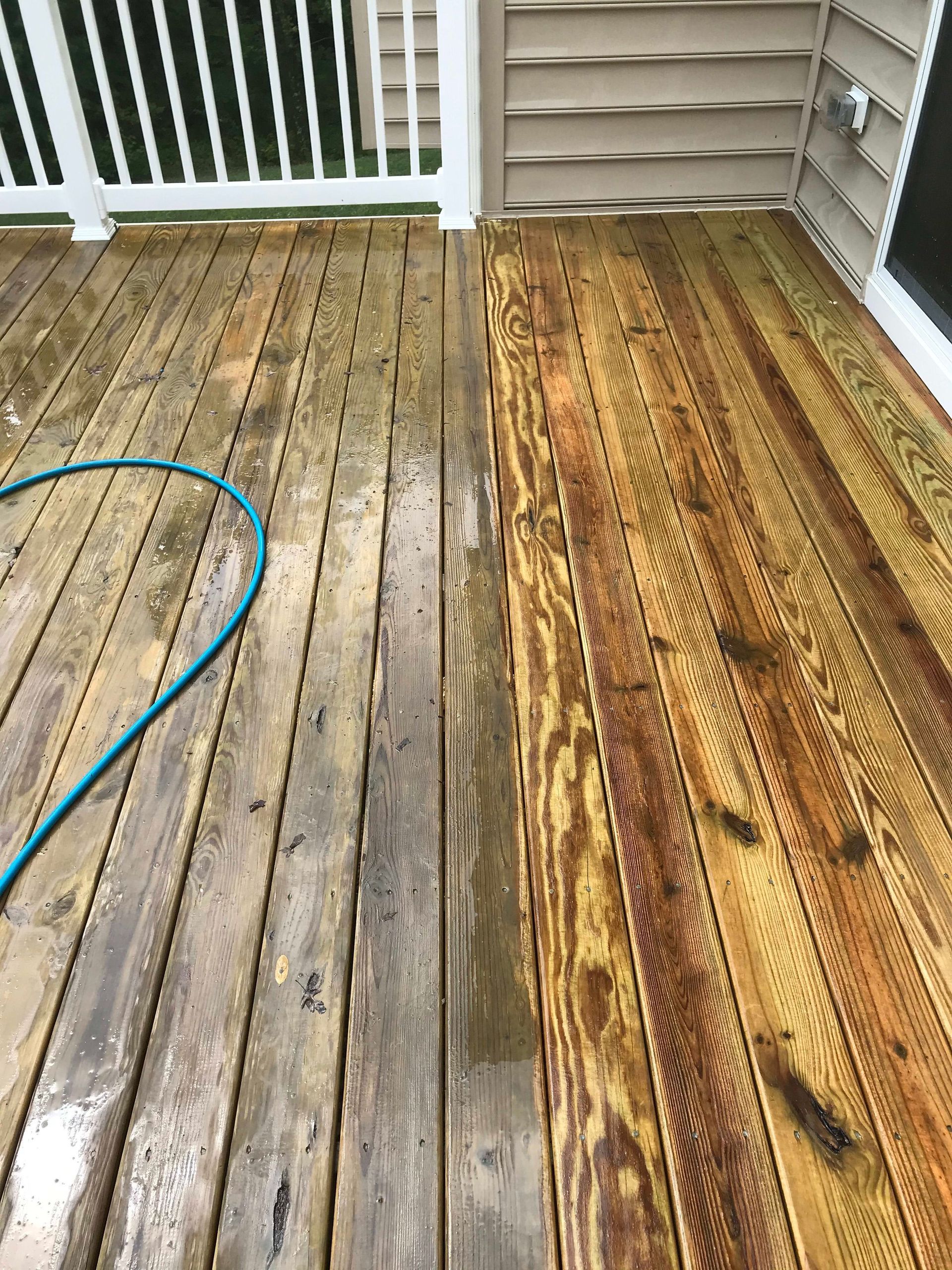 A before and after picture of a wooden deck being cleaned with a hose.