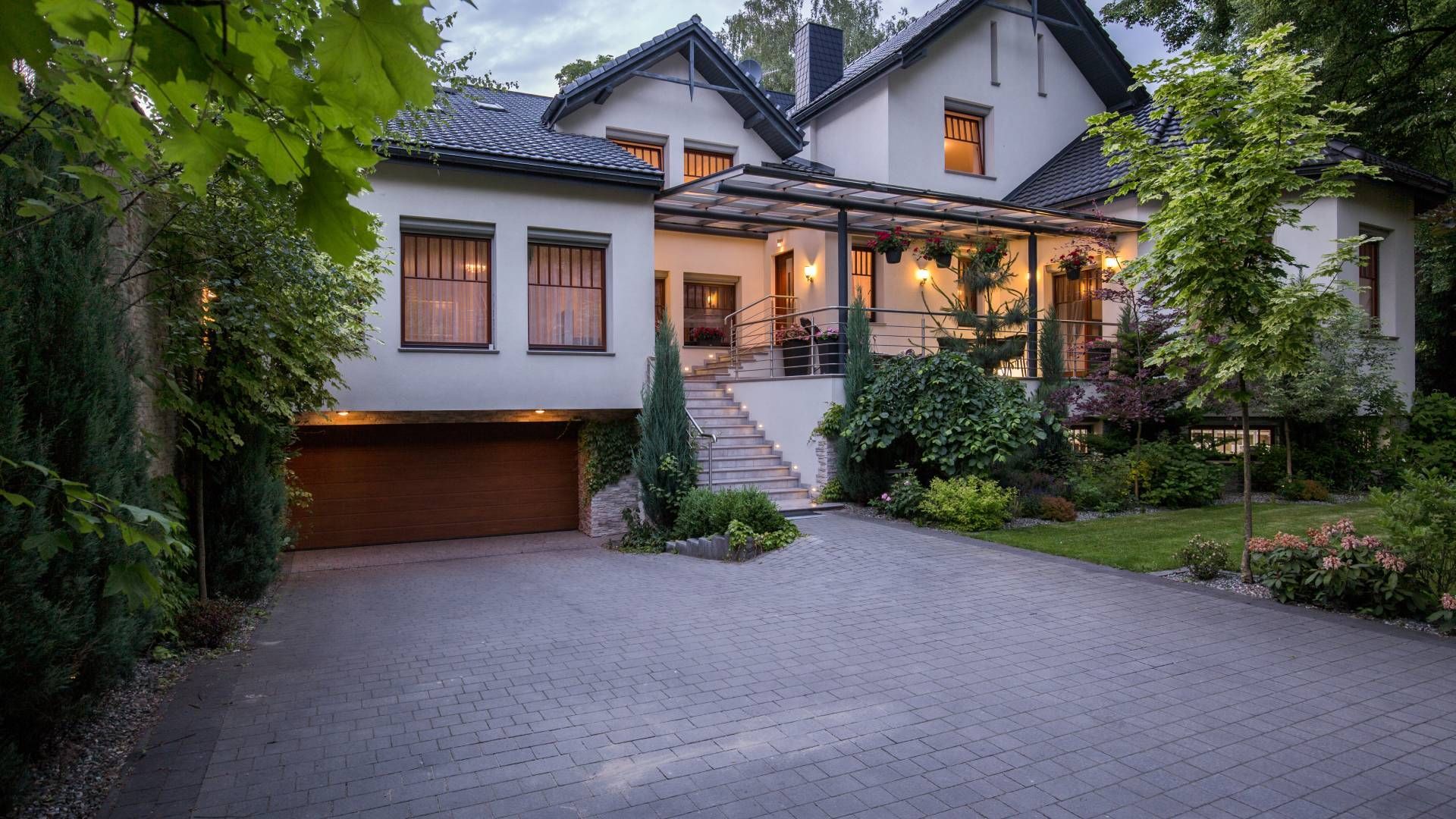 A large white house with a garage and a driveway in front of it.