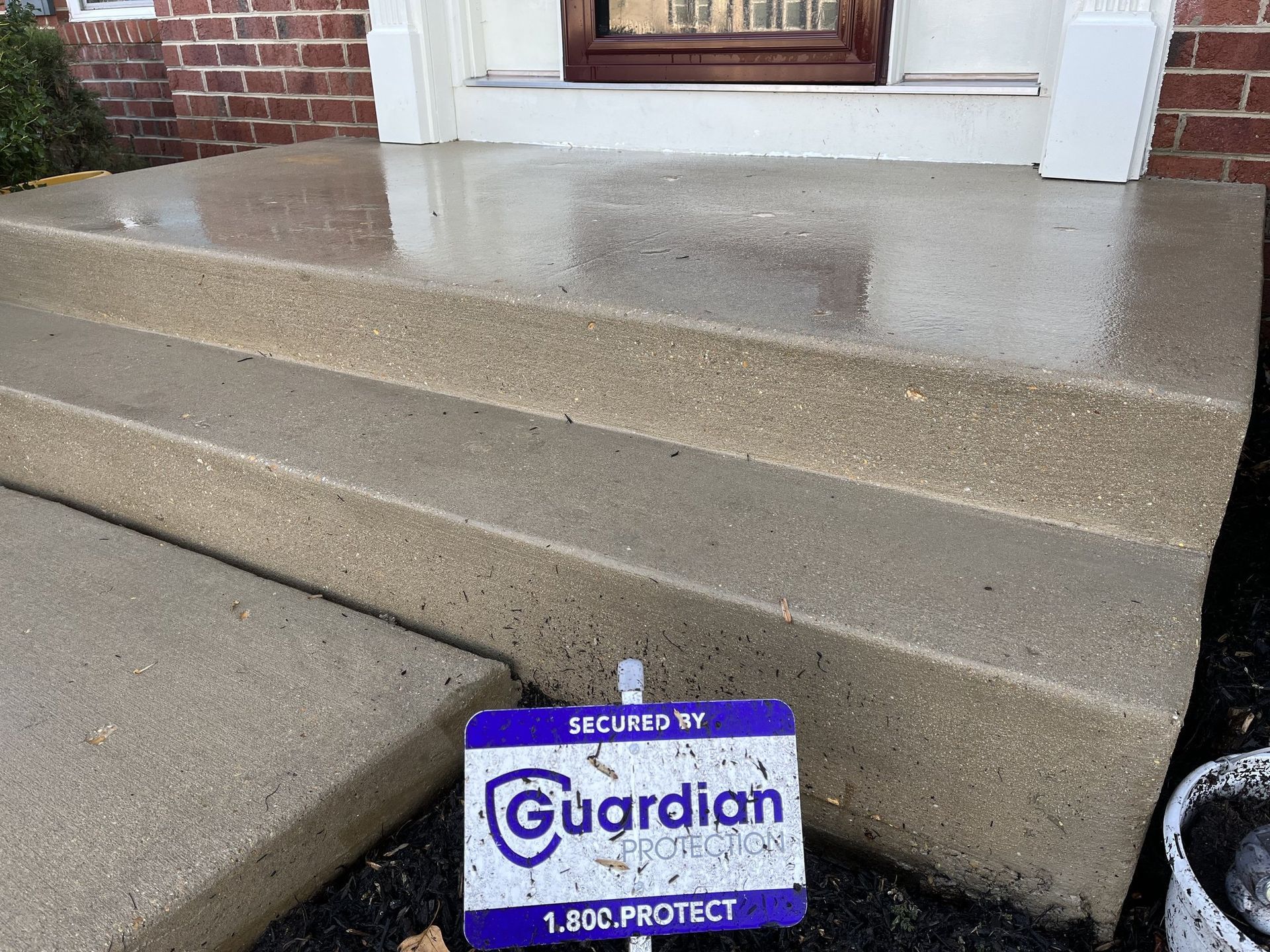 A sign that says guardian on it is on the steps of a house.