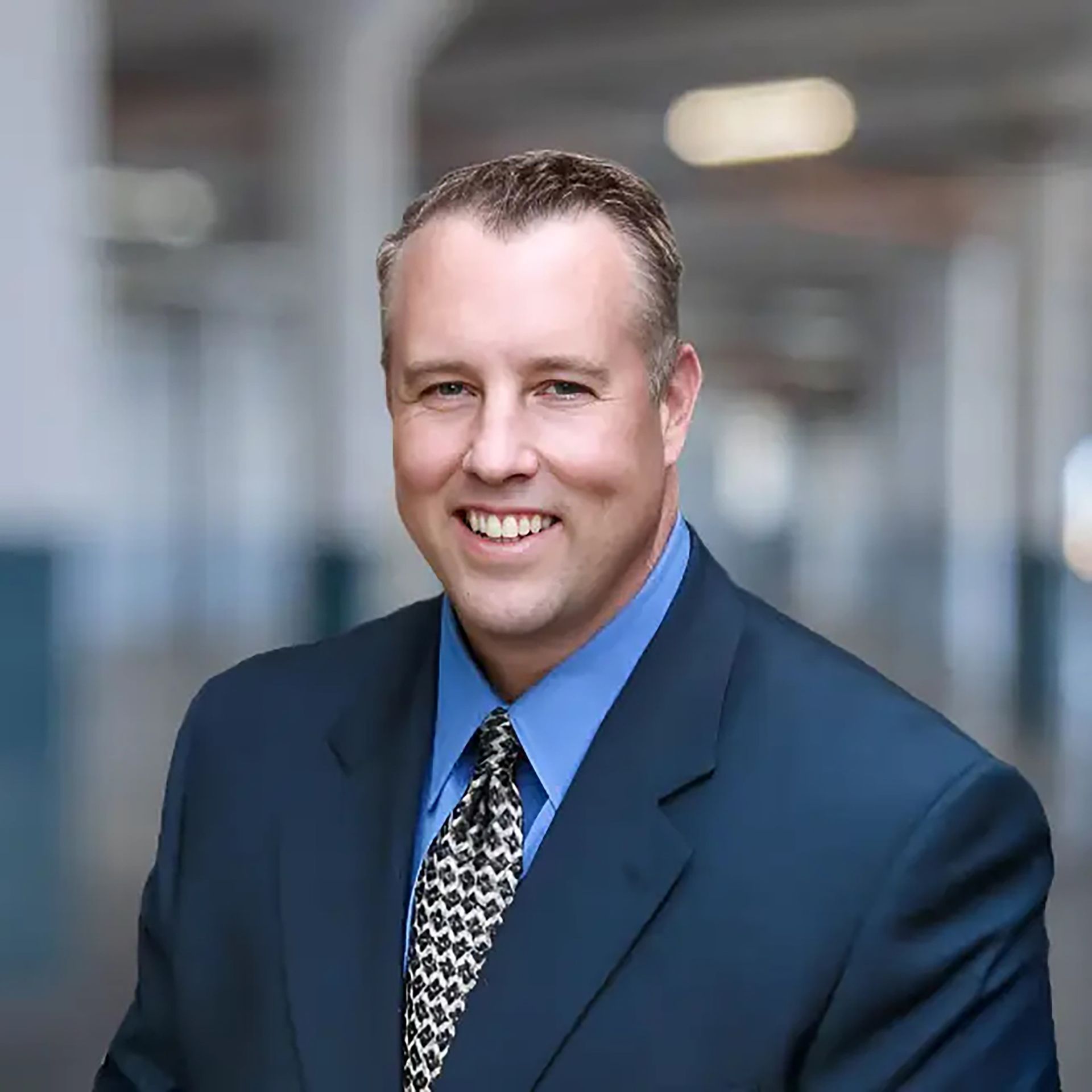 A man and a woman are sitting on a dock overlooking a lake.
